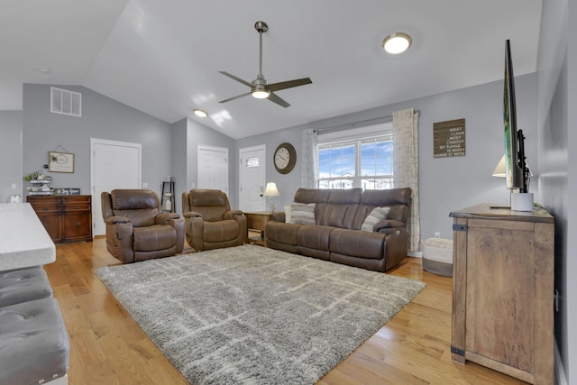 living room with ceiling fan, lofted ceiling, and light hardwood / wood-style floors