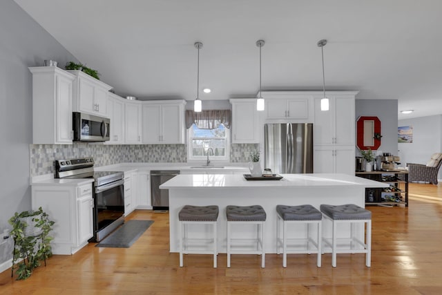 kitchen with white cabinetry, appliances with stainless steel finishes, a center island, and sink