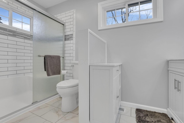 bathroom featuring toilet and a shower with shower door