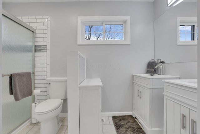 bathroom featuring tile patterned flooring, vanity, a shower with shower door, and toilet