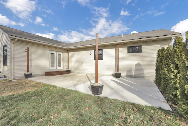 rear view of property featuring a patio and a lawn