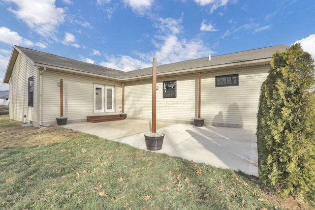 rear view of property with a yard and a patio area