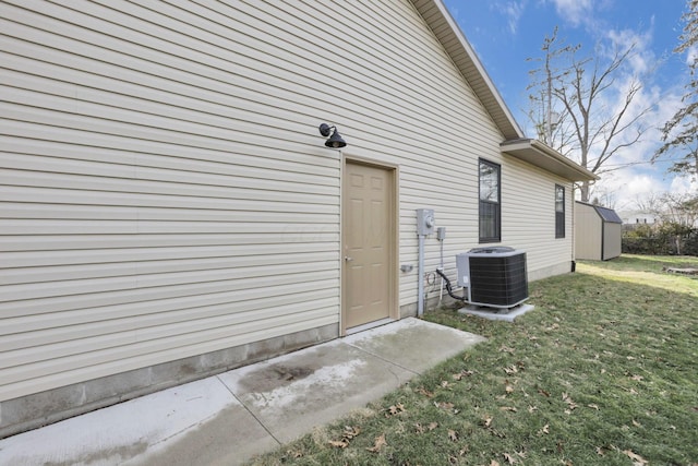 doorway to property with central AC unit and a lawn