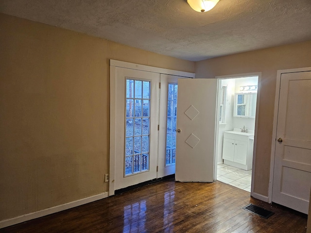 interior space featuring wood-type flooring, sink, and a textured ceiling