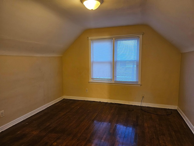 additional living space featuring lofted ceiling and dark hardwood / wood-style floors