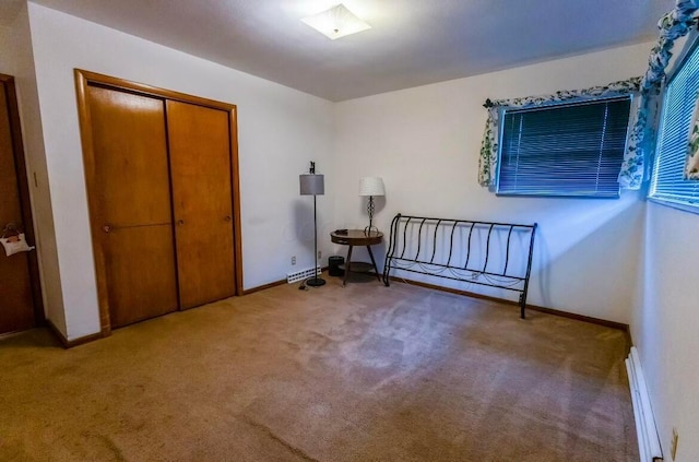 bedroom with a baseboard radiator, carpet floors, and a closet