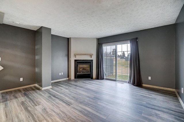 unfurnished living room with hardwood / wood-style floors and a textured ceiling