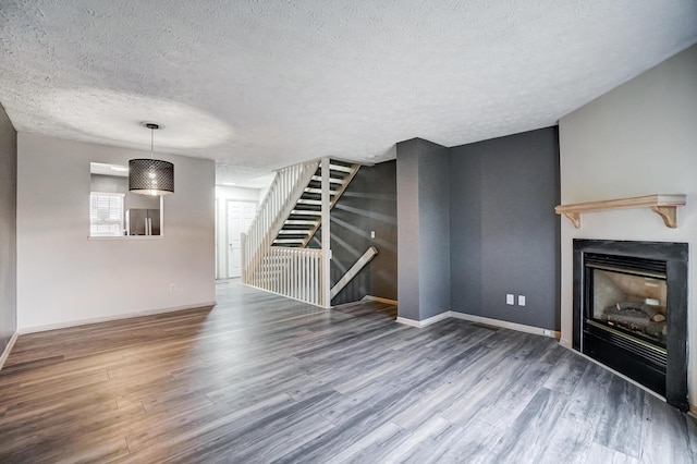 unfurnished living room featuring hardwood / wood-style floors and a textured ceiling