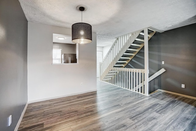 unfurnished room featuring hardwood / wood-style flooring and a textured ceiling