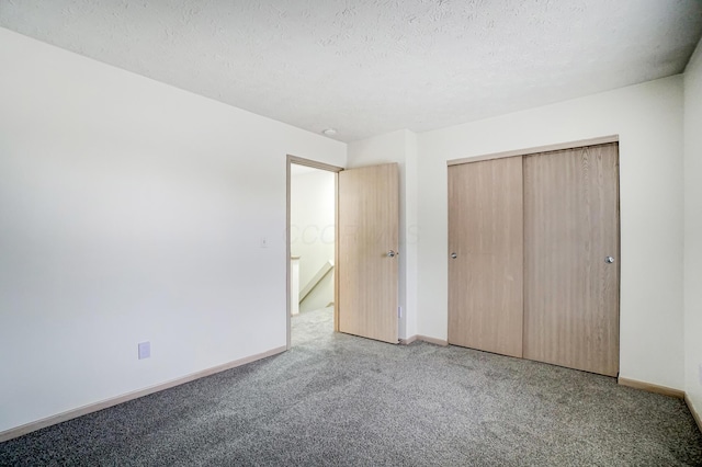 unfurnished bedroom featuring carpet, a textured ceiling, and a closet