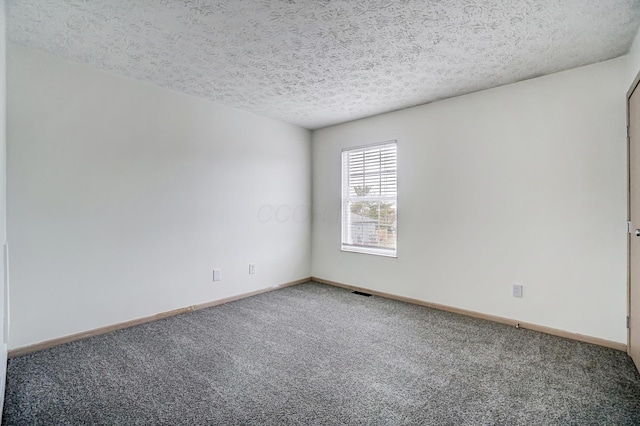 unfurnished room featuring carpet flooring and a textured ceiling