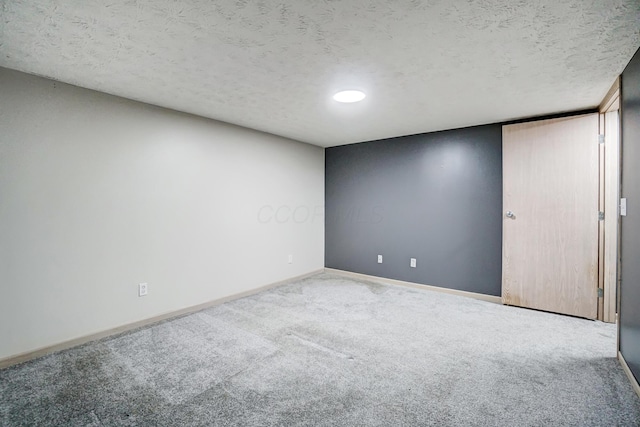 spare room with a textured ceiling and carpet