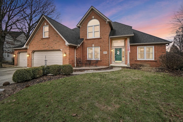 front of property with a garage and a lawn