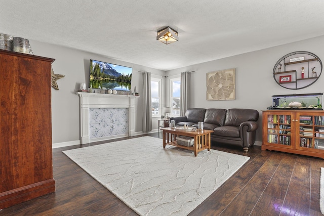 living room with dark wood-type flooring, a textured ceiling, and baseboards