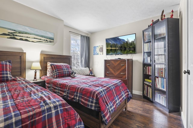 bedroom featuring dark wood-style flooring, a textured ceiling, and baseboards