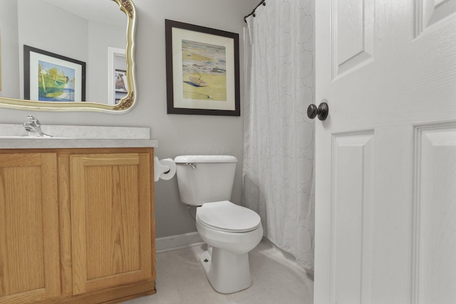 bathroom featuring toilet, vanity, and baseboards