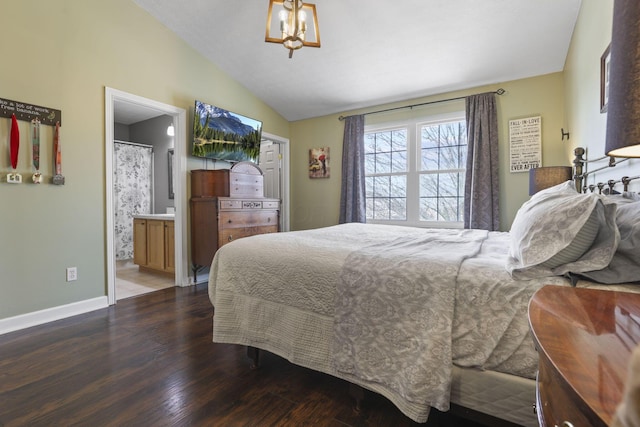 bedroom with ensuite bath, baseboards, vaulted ceiling, and wood finished floors