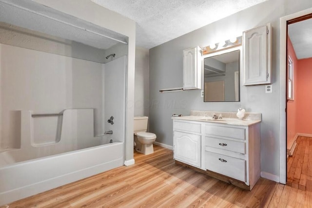 full bathroom with shower / bath combination, hardwood / wood-style floors, vanity, a textured ceiling, and toilet