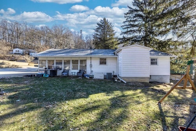 exterior space with central AC, a sunroom, and a front lawn