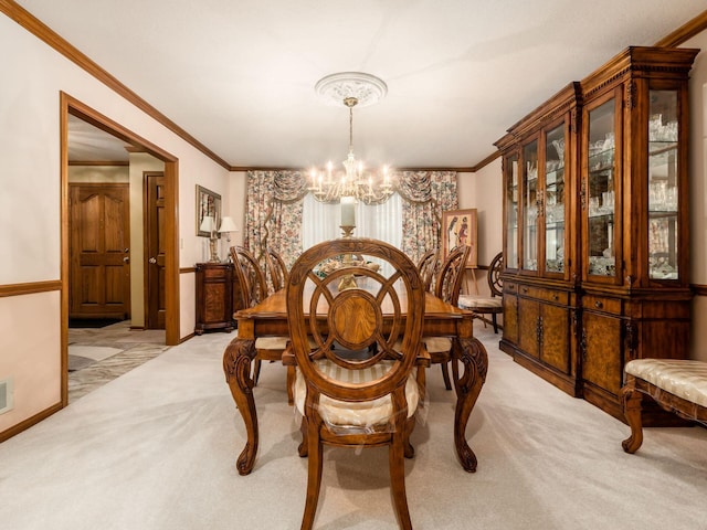 dining area with light carpet, crown molding, baseboards, and a notable chandelier