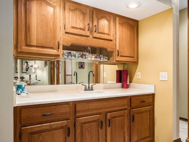 kitchen with light countertops, brown cabinetry, and a sink