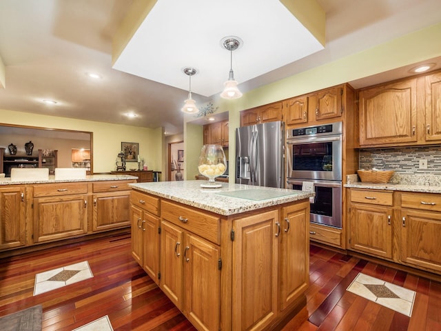 kitchen with a kitchen island, appliances with stainless steel finishes, dark wood-type flooring, and decorative light fixtures