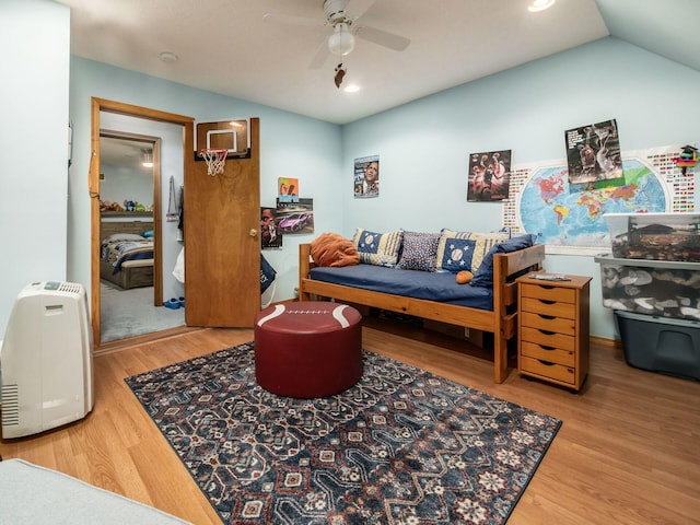 bedroom featuring light wood-style floors, lofted ceiling, and ceiling fan