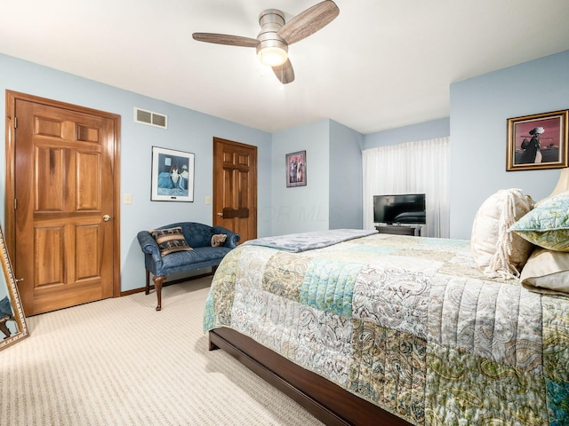 carpeted bedroom with a ceiling fan, visible vents, and baseboards