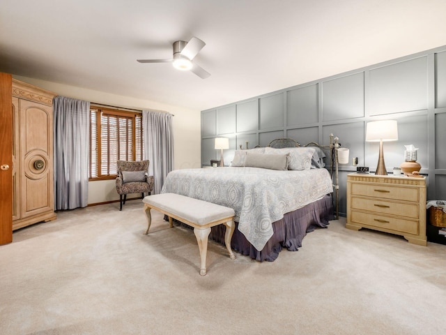 bedroom with light carpet, ceiling fan, and a decorative wall