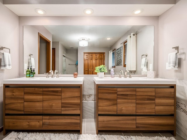 full bath featuring recessed lighting, two vanities, and a sink