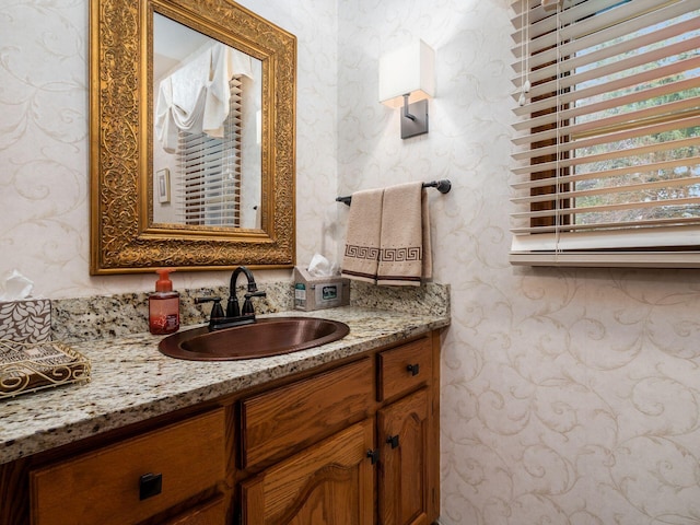 bathroom with vanity and wallpapered walls