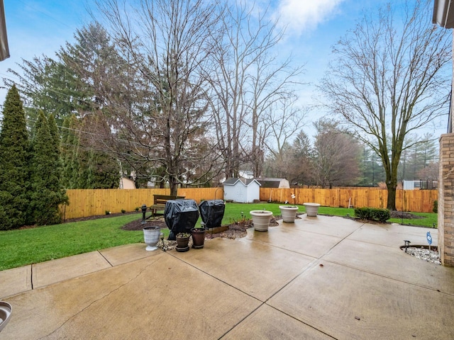 view of patio / terrace featuring an outbuilding, a fenced backyard, and a storage unit