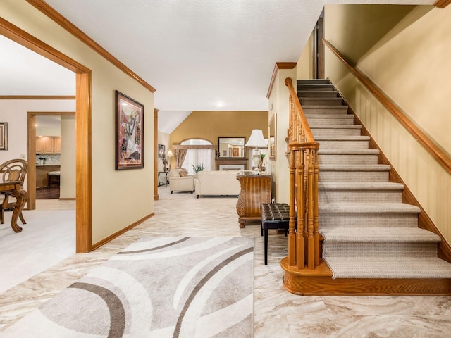 staircase featuring ornamental molding and baseboards