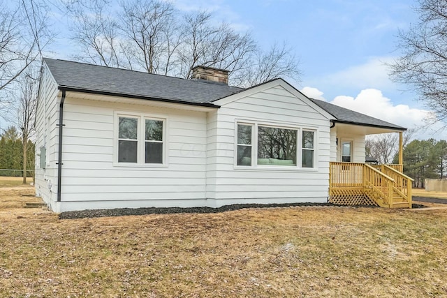 view of side of home with a porch and a lawn