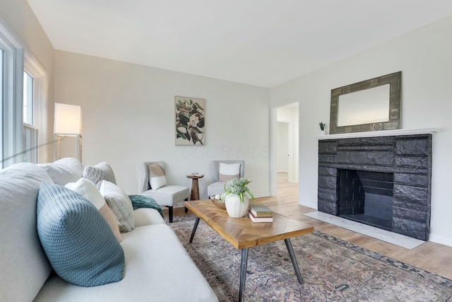 living room featuring a stone fireplace and hardwood / wood-style floors