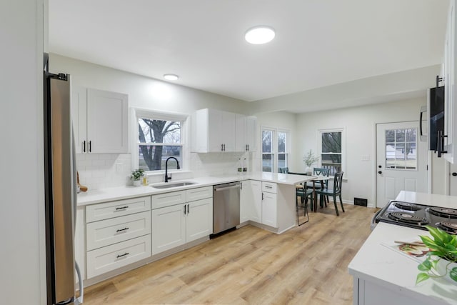 kitchen featuring tasteful backsplash, stainless steel appliances, sink, and white cabinets