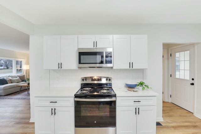 kitchen featuring stainless steel appliances, white cabinetry, and light wood-type flooring