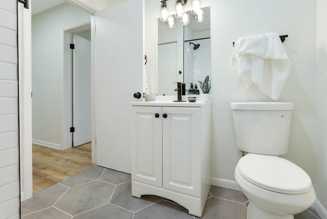 bathroom with tile patterned flooring, vanity, toilet, and a tile shower