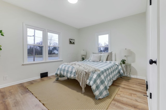 bedroom featuring multiple windows and light hardwood / wood-style flooring