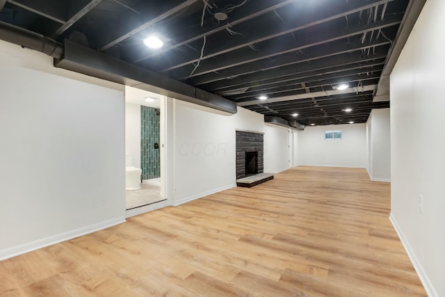 basement with hardwood / wood-style floors and a fireplace