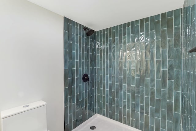 bathroom with toilet and a tile shower