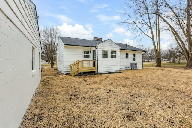 back of house with a yard and central air condition unit