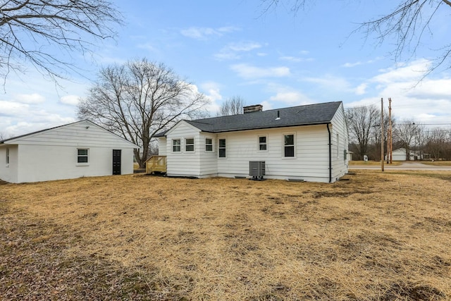 back of property featuring a lawn and central air condition unit