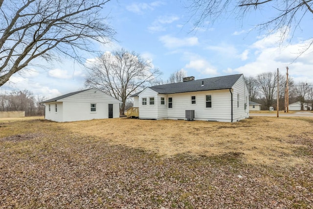 rear view of property with a yard and central AC