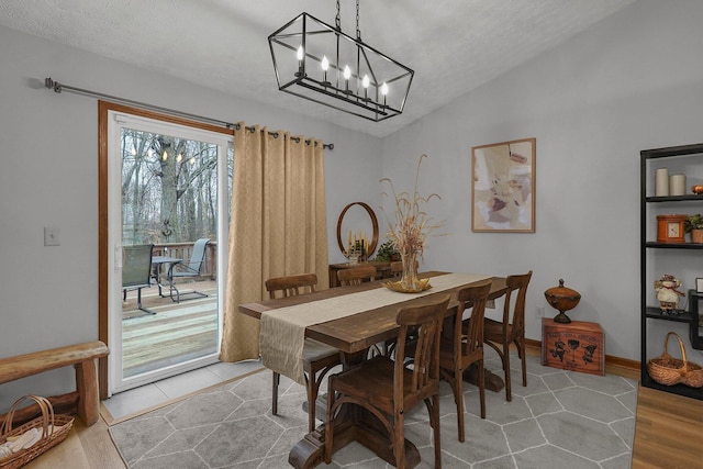 dining room with vaulted ceiling, hardwood / wood-style floors, and an inviting chandelier