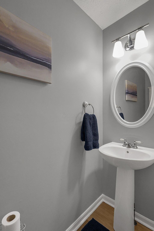 bathroom with wood-type flooring, sink, and a textured ceiling