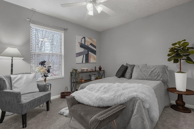 bedroom with ceiling fan, light carpet, and a textured ceiling