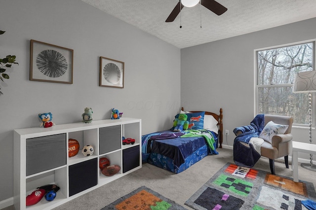 carpeted bedroom with ceiling fan and a textured ceiling