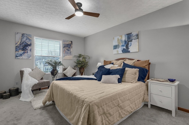 bedroom with ceiling fan, light carpet, and a textured ceiling