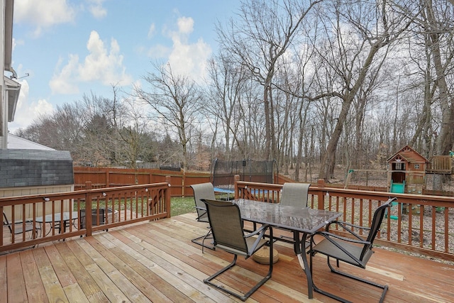 wooden terrace featuring a trampoline and a playground